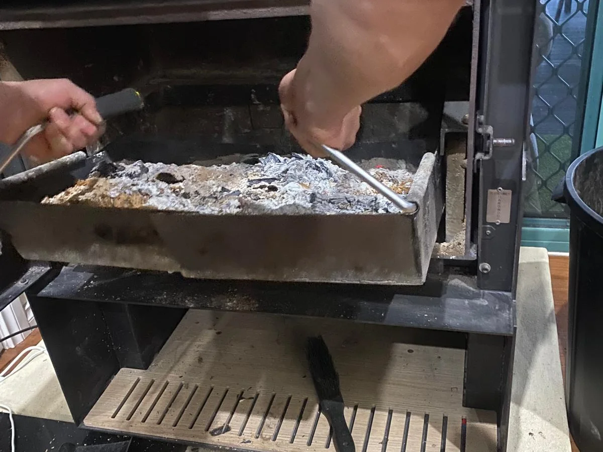 Fireplace tray being removed with ash