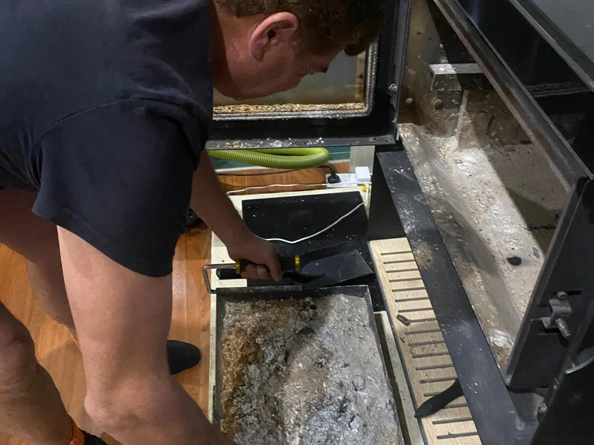 Person removing the fireplace tray