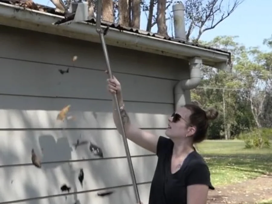 Safety-First Gutter Cleaner reaching a roof gutter