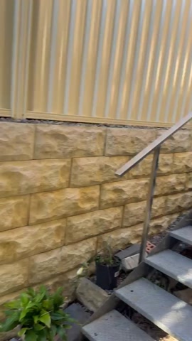 Bessa block retaining wall with sandstone capping, stairs & garden
